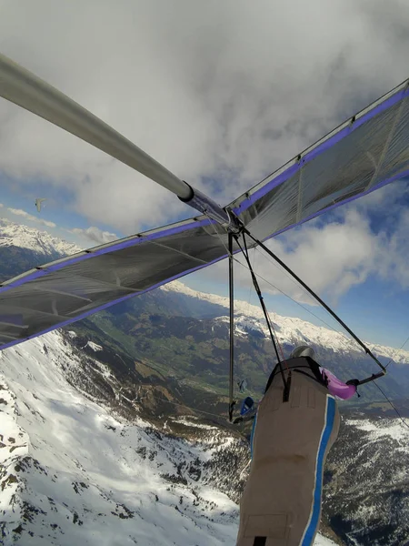 Brave hang glider pilots fly on high altitude over mountain peak