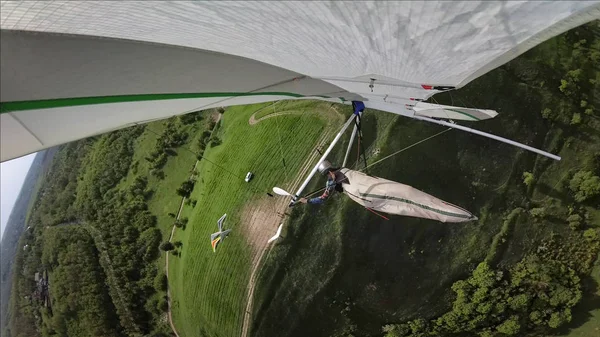 낮은 고도의 녹색 언덕 위의 행 글라이더 파일럿 플라이. — 스톡 사진