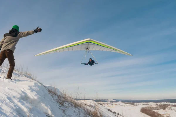 A man trying to catch flying hang glider wing. — Stock Photo, Image