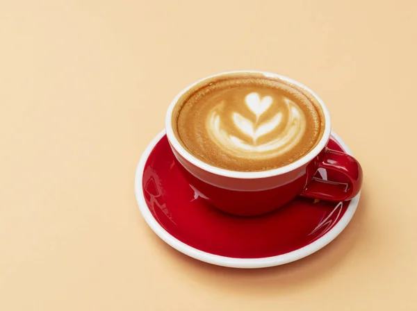 Geschilderde cappuccino in rode beker — Stockfoto