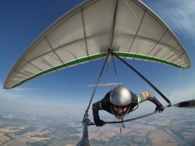Selfie photo of hang glider pilot holding his wing on high altit clipart