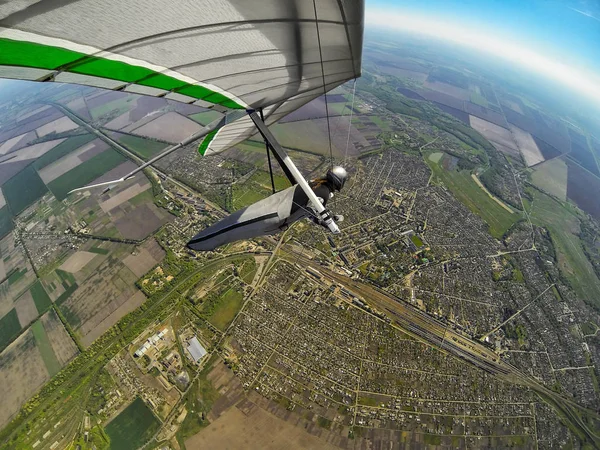 Hang zweefvliegtuig pilot Fly hoog boven de stad en het treinstation. — Stockfoto