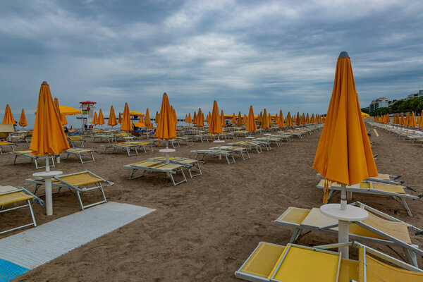 End of the swimming season. Empty beach with closed umbrellas in Grado, Italy