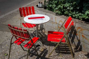 Berlin'de halk caddesinde kırmızı eski ve kırık bahçe sandalyeleri