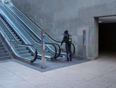 Berlin, Almanya'da bir yürüyen merdiven in yanında duran bir dalış elbisesi giymiş bir adam