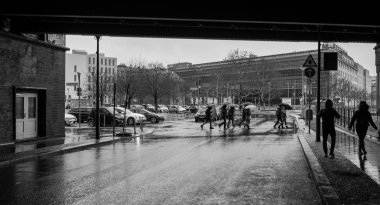Berlin Friedrichstrasse'de yoldan geçenler ve yayalar yağmurlu havalarda, Almanya