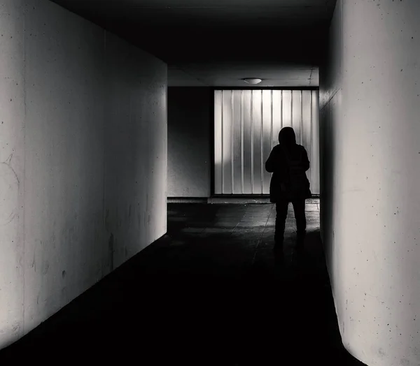 Man met capuchon staat in een doorgang in een Berlijnse hoogbouw, Berlijn, Duitsland — Stockfoto