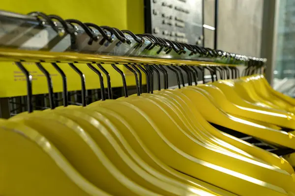 Yellow and other clothes hangers on a wardrobe — Stock Photo, Image