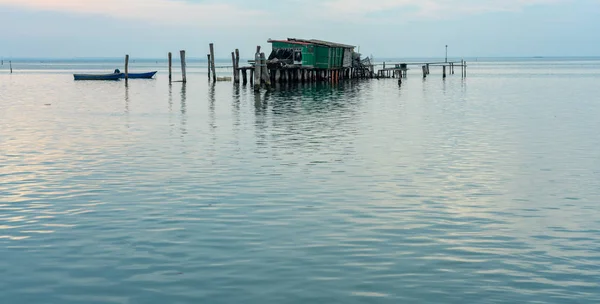 Cabine di pescatori in legno su palafitte al Lido di Venezia con tramonto e lunga esposizione — Foto Stock