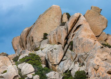 Sardunya Capo Testa kuzey kıyısında deniz feneri ile granit kayalar, İtalya