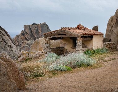 Sardunya Capo Testa kuzey kıyısında deniz feneri ile granit kayalar, İtalya
