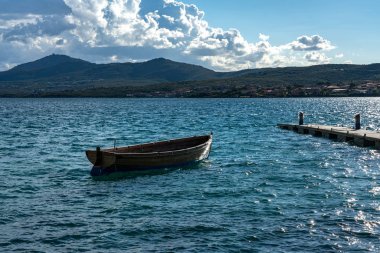sardunya gulfo aranci de figari limanında demirlemiş bir kürek tekne ve bir yelkenli gemi, İtalya