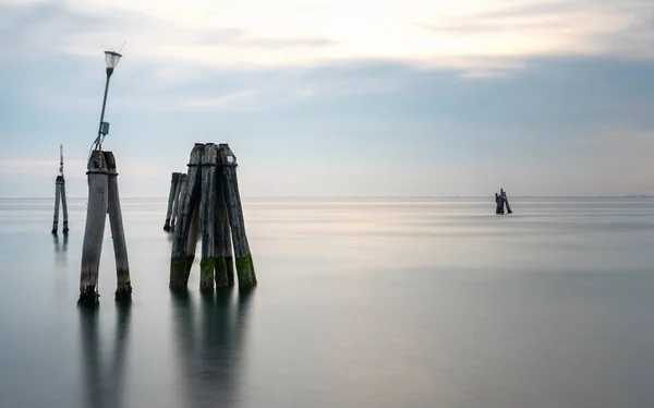 Exposición a largo plazo de pilas y chozas en el mar — Foto de Stock