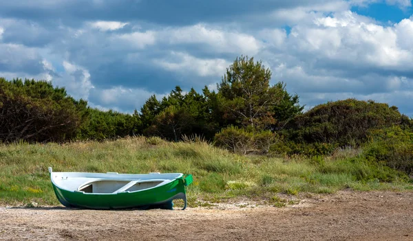 En övergiven trä roddbåt ligger i sanddynerna vid havet, Italien — Stockfoto