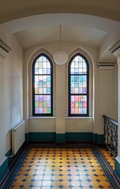 Eski bir Berlin binasının merdiven boşluğu, koridoru ve tarihi pencereleri.