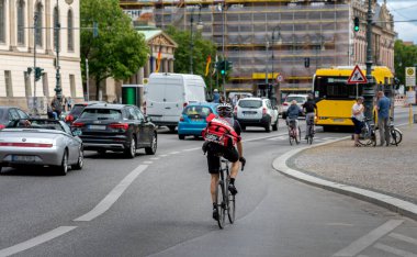 Yoğun saatlerde, bisikletçiler Berlin 'de Unter den Linden' da uçuyor.