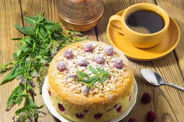 Pudra şekeri ve ahududulu sarı pasta, kız naneyle süslüyor. Yakın çekim..