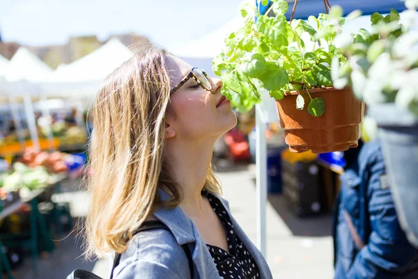 Foto Mujer Joven Bonita Que Huele Planta Mercado Callejero —  Fotos de Stock