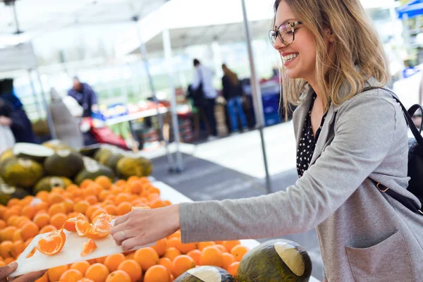 Fotografía Una Mujer Joven Guapa Comiendo Trozos Naranja Mercado Callejero — Foto de Stock