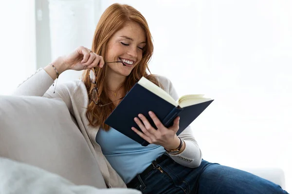 Genç Güzel Kadın Evde Kanepede Otururken Bir Kitap Okuma Kadeh — Stok fotoğraf