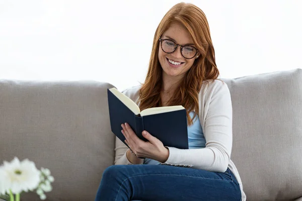 Genç Güzel Kadın Evde Kanepede Otururken Bir Kitap Okuma Kadeh — Stok fotoğraf
