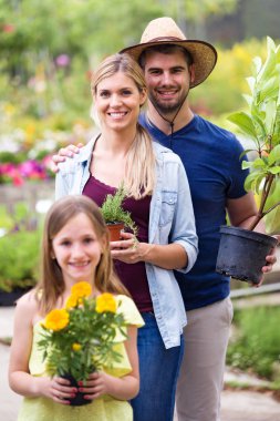 Onlar güzel çiftle portresi kızı kameraya serada bitki tutarken arıyorsunuz.