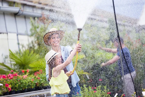 Shot Beautiful Young Woman Her Daughter Watering Plants Hose Greenhouse — Stock Photo, Image