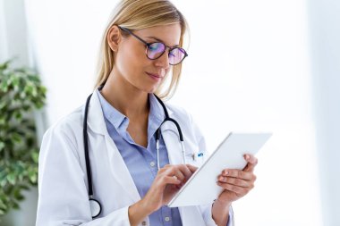 Bir kadın doktor onun dijital tablet danışma süreci kullanarak atış.
