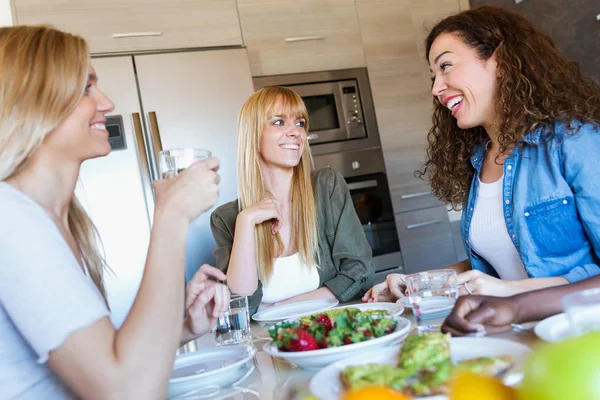 家庭で健康に良い食べ物を食べながら笑っている友人のグループのショット — ストック写真