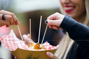 Arkadaş grubunun yakın çekim yemek Pazar ve sokakta patates yeme.