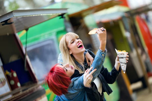 Tiro Dos Hermosas Mujeres Jóvenes Jugando Comiendo Patatas Fritas Calle — Foto de Stock