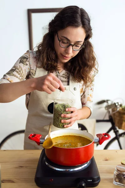 Tiro Mulher Muito Jovem Apimentando Comida Enquanto Cozinha Uma Loja — Fotografia de Stock