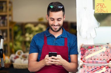 Yakışıklı genç satıcı sağlık bakkal dükkanında onun cep telefonuyla çekim.