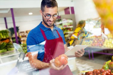 Taze domates seçilmesi sağlık bakkal dükkanında iş günü için hazırlanması ve satıcı kadeh.