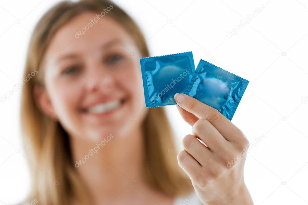 Shot of beautiful smiling woman showing condoms over white background.