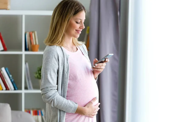 Girato Bella Giovane Donna Incinta Sms Con Suo Smartphone Casa — Foto Stock