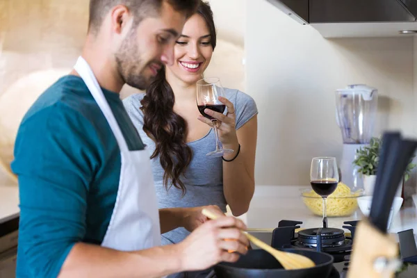 Foto Hermosa Joven Sonriente Bebiendo Vino Tinto Mientras Marido Preparando —  Fotos de Stock