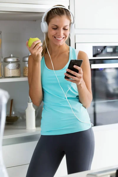 Foto Una Hermosa Joven Deportista Escuchando Música Con Smartphone Mientras —  Fotos de Stock