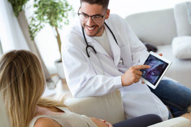Hamile kadın ultrason için gösterilen genç erkek jinekolog doktor doz bebek dijital tablet ile tarama.