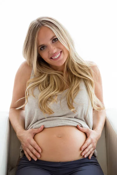 白い背景の上の腹に触れる中で カメラを見て美しい若い妊婦の肖像画 — ストック写真