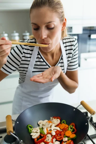 Tiros Mulher Jovem Saudável Cozinhar Degustação Alimentos Com Colher Madeira — Fotografia de Stock