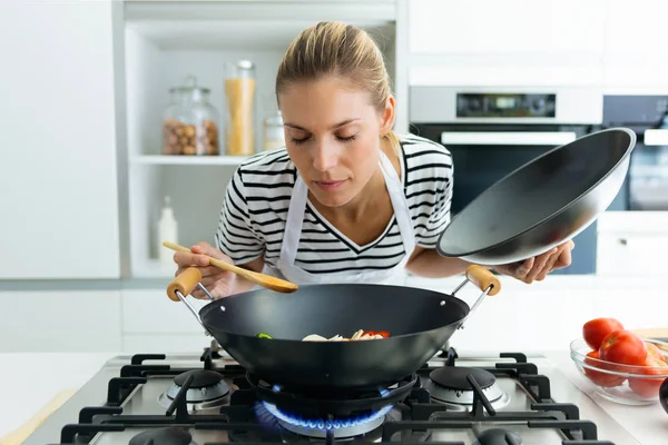 Foto Mujer Joven Saludable Cocinando Oliendo Comida Sartén Cocina Casa —  Fotos de Stock