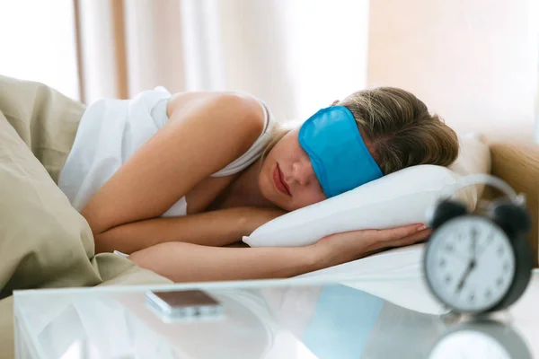 집에서 침실에 시계와 침대에서 마스크와 잠자는 여자의 — 스톡 사진