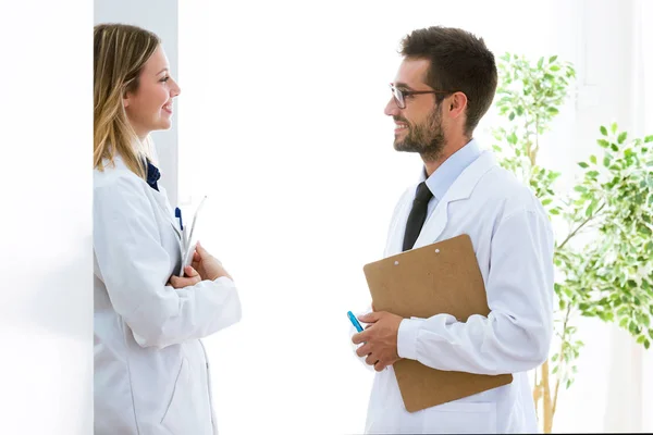 Jeunes médecins souriants confiants qui parlent de travail dans un cabinet médical . — Photo