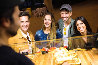 Atış seçme ve farklı fast food alış çekici genç arkadaş Grubu'nun sokak pazarında yemek.