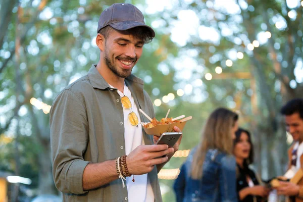 Çekici Bir Genç Adam Sokak Pazarında Holding Patates Yemek Yerken — Stok fotoğraf