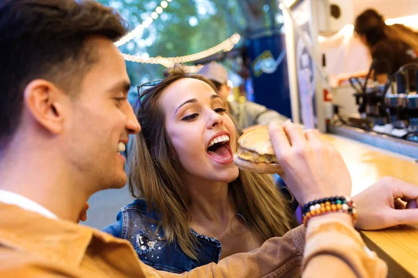 Strzał Atrakcyjnego Młodego Mężczyzny Dając Hamburger Jego Piękna Dziewczyna Jedzenia — Zdjęcie stockowe