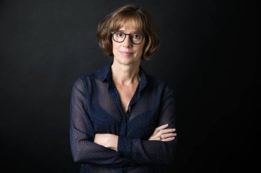 Gözlük kamera siyah arka plan üzerinde seyir ile güzel yetişkin kadın portresi.