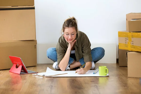 Shot Pretty Young Woman Drawing Blueprints Her New House While — Stock Photo, Image