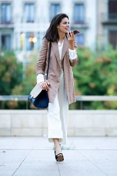 通りで彼女の携帯電話で話しているファッション若い美しい女性実業家のショット — ストック写真
